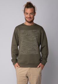 Olijfgroene sweatshirt met lange mouwen, voorzien van een wit golvend lijnpatroon dat lijkt op kattencontouren over de voorkant. Zachte textuur.