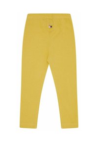 Gele leggings van zacht, rekbaar materiaal. Heeft een effen ontwerp met een klein gekleurd label aan de achterkant van de tailleband.