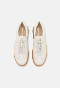 Hvite lær sneakers med rund tå, lysegr�å lisser og en gummisåle. Merking trykt i gull på siden.