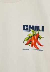 Racimo de chiles rojos con hojas verdes, texto "CHILE" y "Capsicum Annuum," y coordenadas "N 09°45' / W 83°45'" sobre tela blanca.