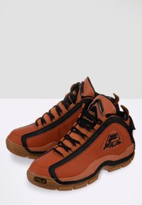 Paire de baskets montantes FILA marron et noir avec semelles en gomme, lacets noirs et détails du logo sur les côtés et à l’avant.