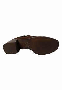 Zapato de tacón alto marrón con suela de goma texturizada, tacón cuadrado y acento metálico en la correa. Parte superior de tela suave con costuras detalladas.