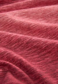 Tejido rojo con una superficie suave y texturizada, que presenta un sutil patrón ondulado y ligeras variaciones en el tono del color.