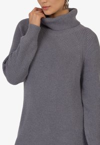 Grijze geribde coltrui met een relaxte fit, voorzien van een chunky textuur en lange mouwen, die een subtiele, gezellige uitstraling heeft.