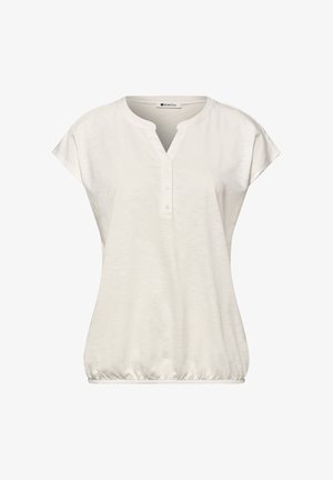 Blusa blanca de manga corta con cuello redondo, tapeta con tres botones, corte holgado y bajo elástico.