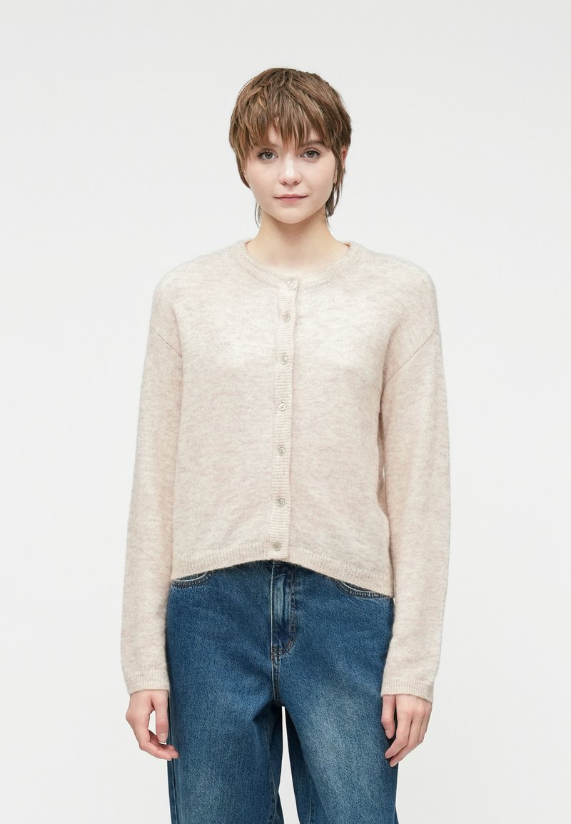 Helle rosa gestrickte Strickjacke mit langen Ärmeln, Rundhalsausschnitt und Knopfverschluss vorne. Weiche Textur und taillierte Passform mit geripptem Saum.