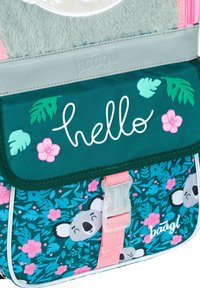 Batoh má tyrkysovou látku s vzory koaly a květin, růžový popruh a šedou horní část s nápisem "hello" v bílém kurzívou.