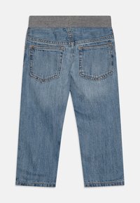 Vista posteriore di pantaloni in denim blu per bambini con due tasche posteriori e una cintura elastica grigia.