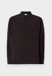 Camisa preta de manga longa com um padrão de bolinhas vermelhas, fecho frontal com botões, colarinho pontudo e bolso no peito. Textura do tecido suave.