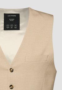 Gilet beige ajusté avec deux boutons marron, petite poche poitrine, et étiquette intérieure noire indiquant "s.O PURE" ainsi que des icônes d'entretien du tissu.