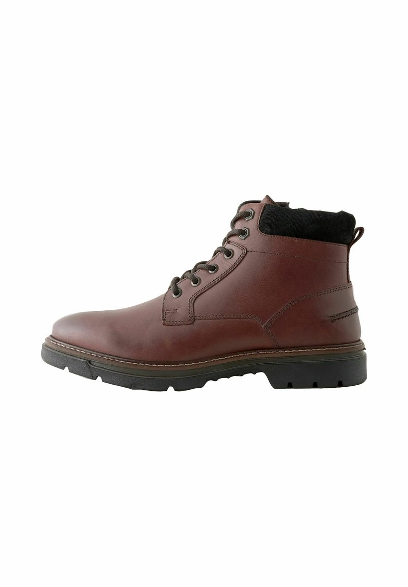 Braune Lederstiefelette mit schwarzem Textilkragen, runder Zehenform, sechs metallischen Ösen und einer strukturierten Gummisohle für besseren Halt.