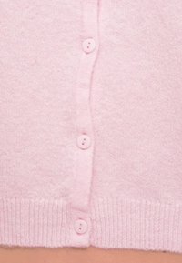 Φουξον ροζ πλεκτή ζακέτα με έξι κουμπιά σε ίδιο χρώμα και ριμπ τελείωμα. Απαλή υφή με απλό, κλασικό σχέδιο.