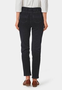 Dunkelblaue, dehnbare Jeans mit elastischem Bund und zwei hinteren Taschen. Slim-Fit-Design, das an den Knöcheln schmal zuläuft.