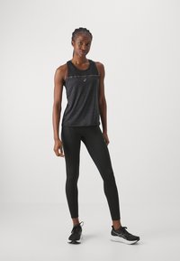 Black athletic tank top with a textured pattern, paired with black leggings. The outfit features the Asics logo and is suitable for activewear.