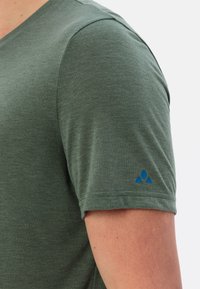Groene T-shirt met korte mouwen van zachte stof, met een v-hals ontwerp en een klein blauw logo op de linkermouw.