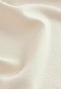 Light cream fabric with a smooth texture, featuring subtle surface variations and a soft, draping quality. Ideal for various textile applications.