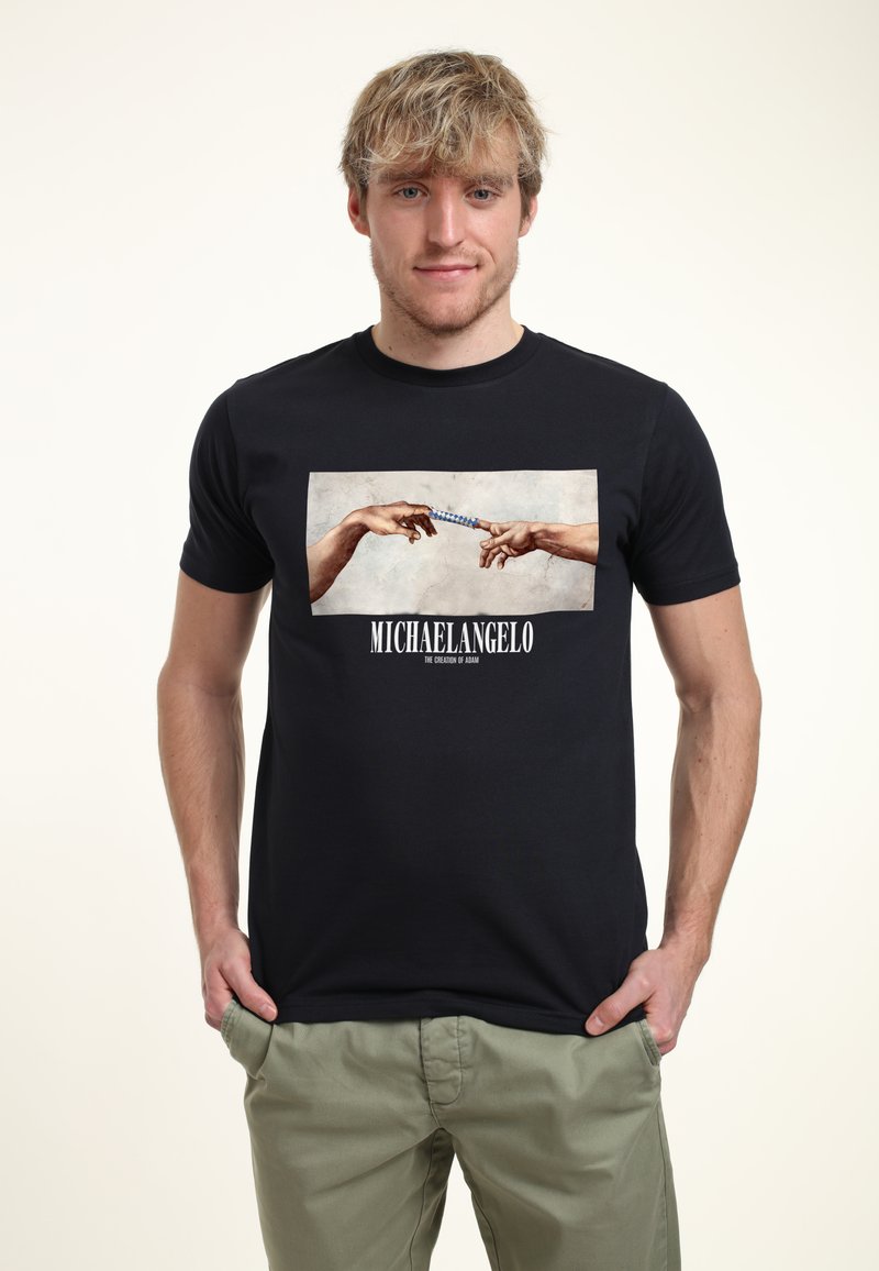 Černé bavlněné tričko s potiskem grafiky rukou, které si sahají navzájem, s textem "MICHELANGELO" níže. Volný střih, krátké rukávy.