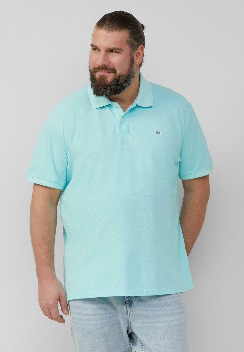 Lichtblauwe poloshirt gemaakt van zachte stof, met een klassieke kraag en korte mouwen. Klein logo op de borst. Gerged met lichtdenim jeans.