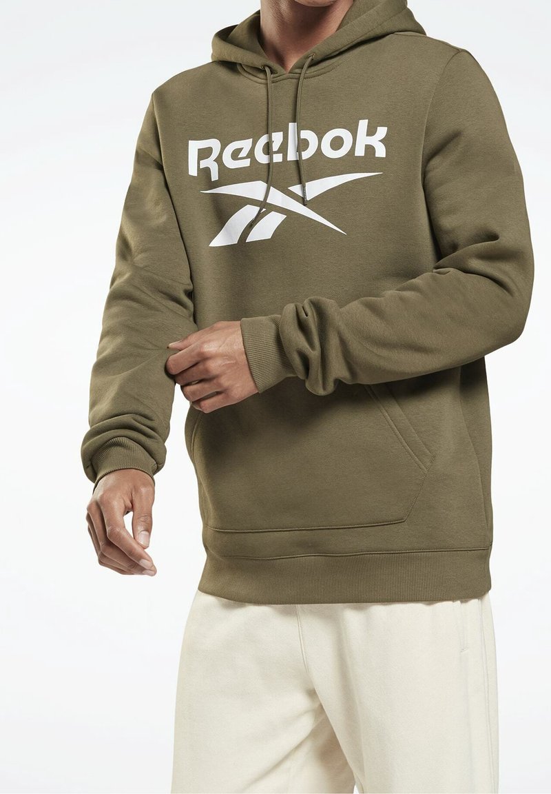 Olivgrüner Reebok-Hoodie mit großem weißen Logo, Kapuze mit Kordelzug und Vorderseite-Tasche. Gerippte Bündchen und Saum mit glatter Textur.