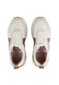 Sneakers lacci bianchi e marroni con suole spesse, visti dall'alto, che mostrano colli imbottiti e suole in pelle.