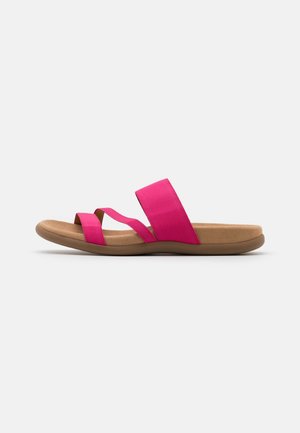 Lyserøde flade sandaler med to brede stofstropper, en blød tan-farvet fodseng og en fleksibel gummisål. Glat tekstur og minimalistisk design.