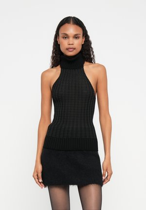 Melns halter tipa tops no tekstūru aušanas ar ribotu augstu apkakli un apakšmalu. Kombinēts ar īsu, pūkainu melnu svārku. Viegla, pieguļoša forma.