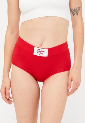 Rode katoenen hoge taille slipjes met een witte merkband. Zachte textuur en naadloos ontwerp. Geen extra patronen of accenten.