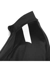 Zwarte sportshirt met een hoge kraag. Heeft een witte accentpanel op de schouder, gemaakt van lichtgewicht, gladde stof.