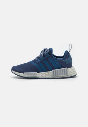 Baskets basses Adidas bleu marine avec dessus en maille, lacets à motifs, trois bandes sur le côté, semelle blanche texturée et languette au talon.