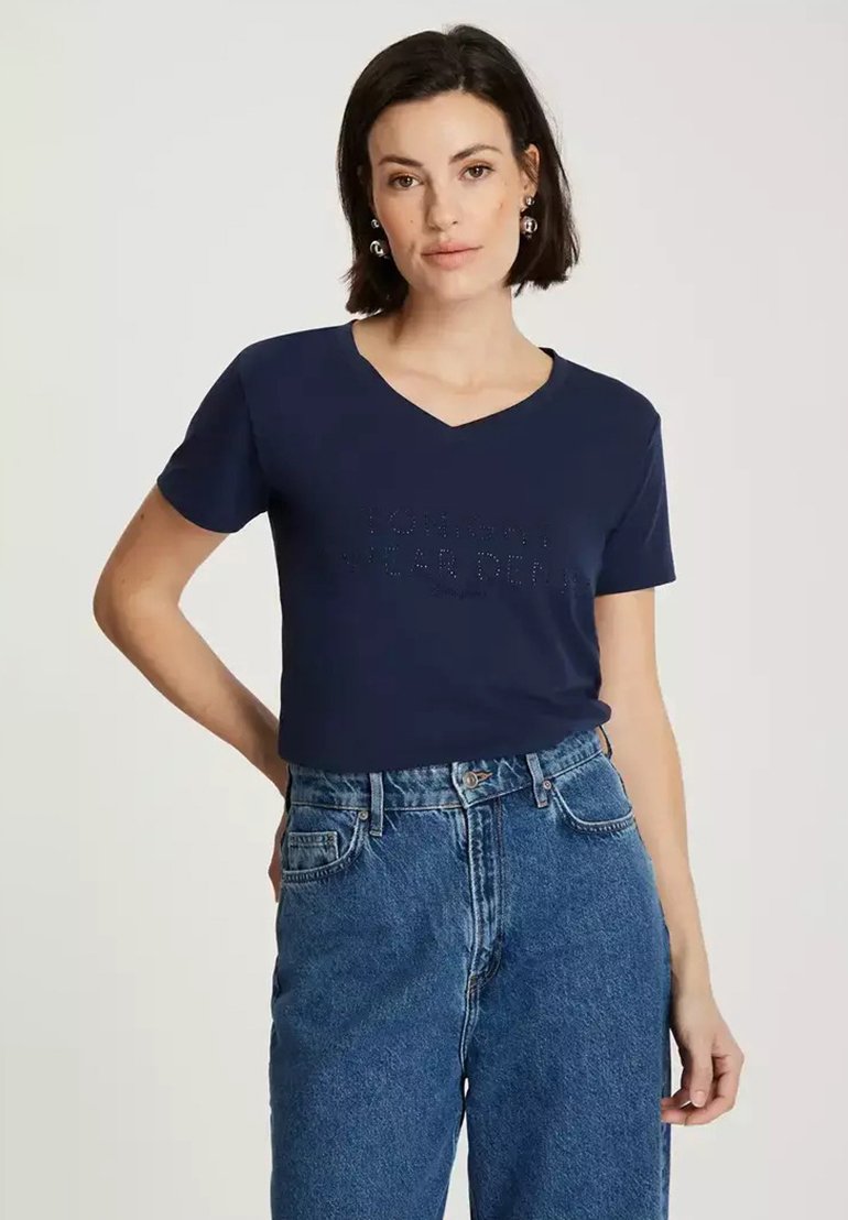 Granatowa koszulka typu V-neck z krótkim rękawem, z wypukłym napisem. Połączona z jasnoniebieskimi dżinsami o wysokim stanie.