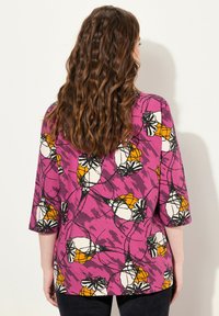Lila Baumwollhemd mit 3/4-Ärmeln, das ein florales Muster in Weiß und Orange aufweist, mit strukturierter Oberfläche und schwarzen Umrandungen, lässige Passform.