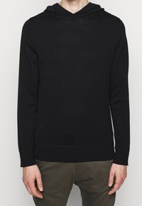 Felpa nera con cappuccio e maniche lunghe, realizzata in tessuto morbido. Presenta un design a V e polsini e orlo a coste. Nessun motivo o accentuazione.