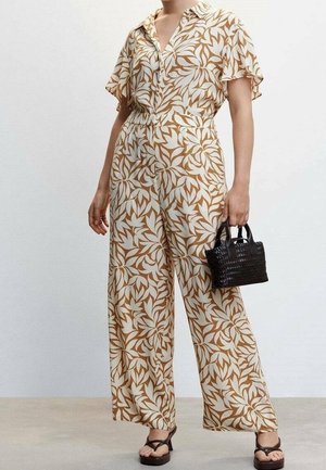 Blumenmuster, creme- und braunfarbener Jumpsuit mit kurzen Ärmeln, geknöpftem Vorderteil, weitem Bein und tailliertem Bund, kombiniert mit einer kleinen schwarzen Tasche.
