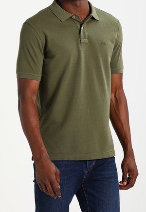 Polo shirt in olijfgroene katoen. Beschikt over een kraag, een knoopsluiting met twee knopen en een klein logo op de borst. Gepaard met denim jeans.