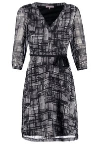 Abito a righe in bianco e nero con scollatura a V, maniche a tre quarti, vita cinchata e cintura con fiocco. Realizzato in tessuto leggero e testurizzato.