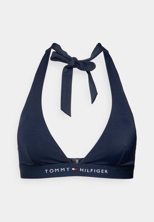 Haut de bikini dos nu bleu marine en tissu lisse. Il présente un décolleté en V profond, des bretelles réglables à nouer et une bande élastique de marque en bas.