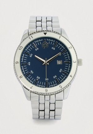 Silver metal watch with a round blue textured dial, silver hour markers, and a date display. Features a stainless steel bracelet strap.