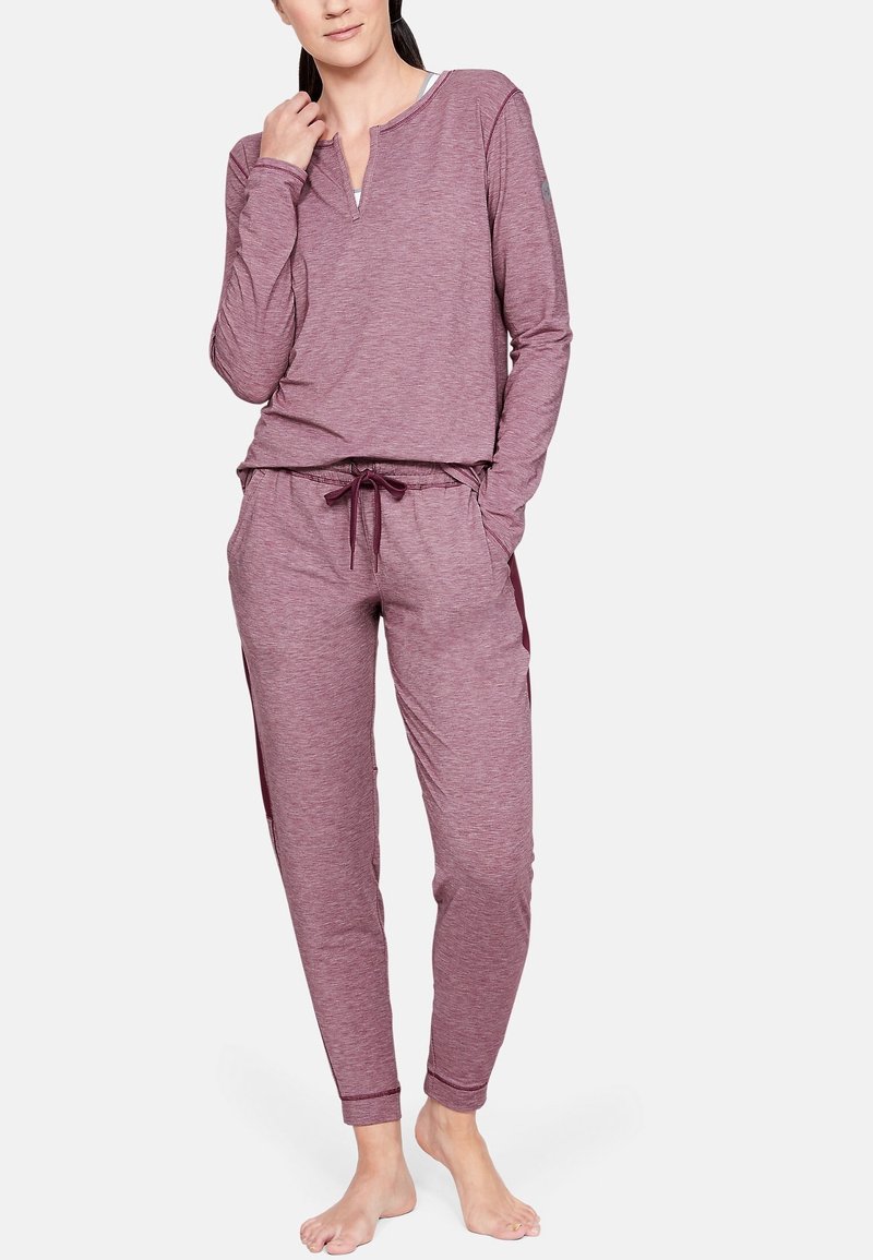 Fialová halenka s dlouhými rukávy a henley výstřihem, doplněná o odpovídající jogger kalhoty s elastickým pasem a bočními kapsami. Hladká textura.