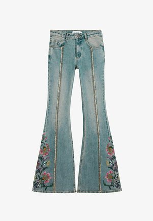 Jean évasé bleu avec broderie florale sur les parties inférieures latérales, présentant un effet délavé et des coutures effilochées. Conception à cinq poches.