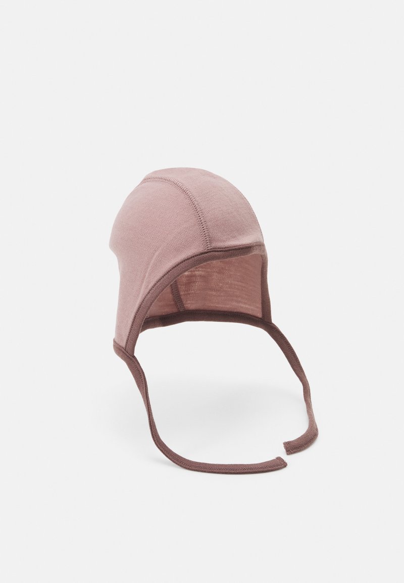 Gorro de bebé de algodón suave en color rosa claro con una corona ajustada y redondeada, ribete marrón y correas para la barbilla que aseguran un buen ajuste. Detalles de costura visibles.