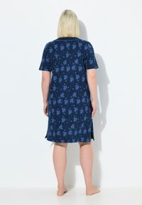 Abito blu navy con motivo floreale in azzurro chiaro. Maniche corte e sventagli ai lati dell'orlo. Tessuto morbido e leggero.