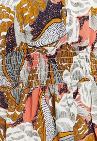 Stoff mit floralem Muster in Orange, Pink und Schwarz. Gepuffter Oberteil mit Nähdetails. Leichtes, strukturiertes Baumwollmaterial.