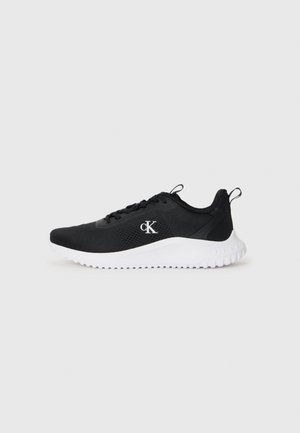 Black athletic shoe with a textured mesh upper, white sole, raised accents, and a small logo on the side. Lightweight design for comfort.