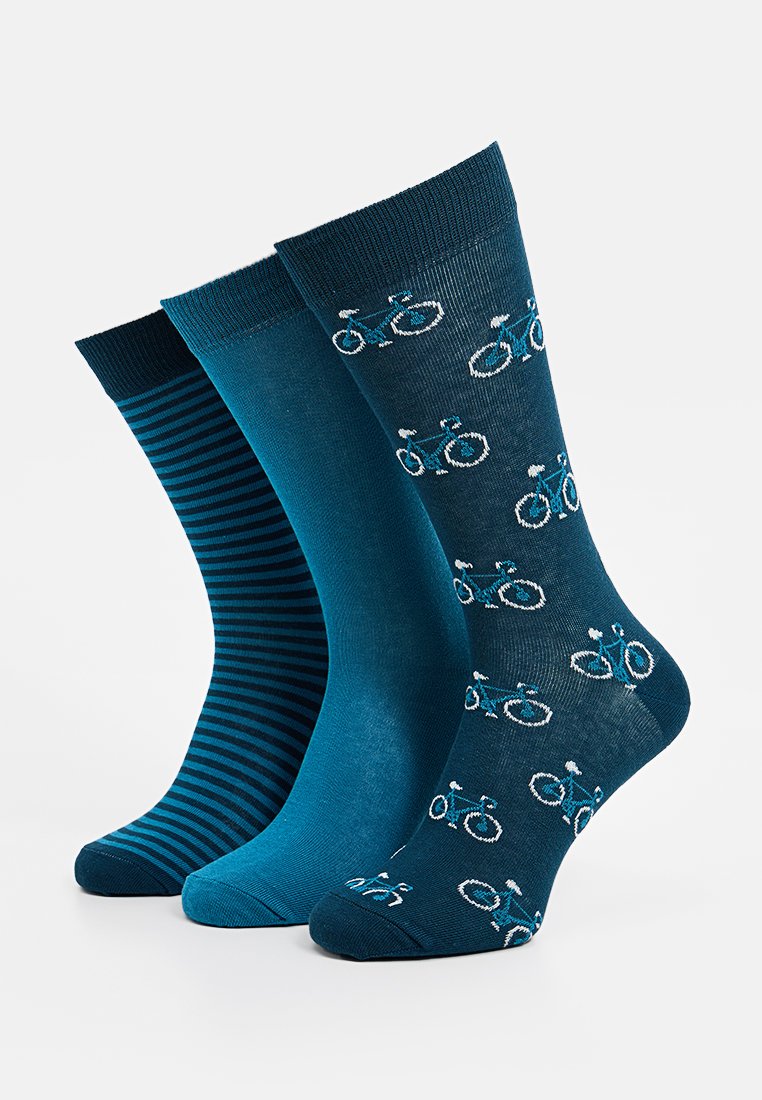 Drie paar sokken in verschillende tinten blauw. Eén heeft een fietsenpatroon, de andere is effen en de laatste heeft een gestreepte textuur.