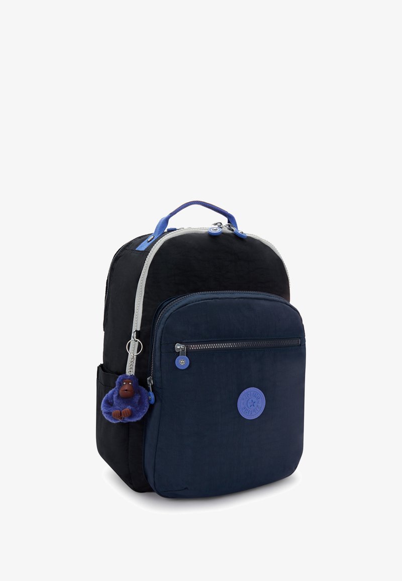 Zaino in tessuto nero e blu con zip argentata, manico superiore e portachiavi a forma di scimmia blu distaccabile. Presenta un patch rotondo con logo sul frontale.