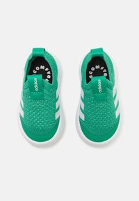 Zelené slip-on tenisky s texturovaným pleteným svrškem, bílou gumovou podrážkou a třemi bílými pruhy po stranách. Obsahují značkový zelený pásek na patě.