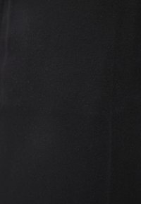 Black fabric with a smooth texture, featuring a consistent matte finish and minimal detailing, showing subtle stitching along one edge.