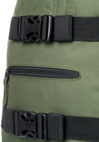 Grüner Stoffrucksack mit schwarzen Kunststoffschnallen und -riemen. Verfügt über eine horizontale Reißverschlusstasche und eine strukturierte Oberfläche.