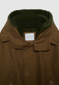 Cappotto marrone con chiusura a bottoni, tasche laterali e un spesso colletto foderato in pile verde, taglia grande con etichetta del marchio Calliope visibile.