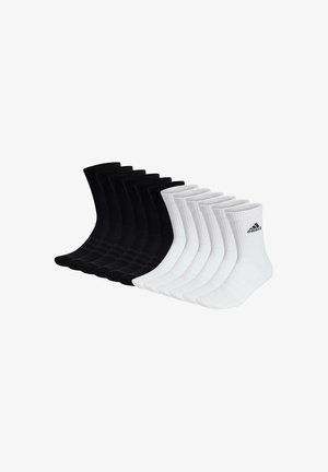 Nueve pares de calcetines hasta el tobillo en negro y blanco, con textura acanalada, y con el logo de Adidas en el lado de cada par blanco.